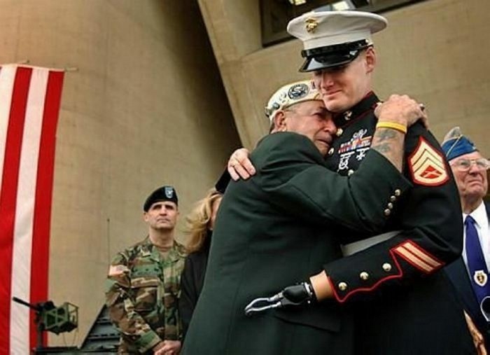Pearl Harbor survivor Houston James of Dallas embraces Marine Staff Sgt. Mark Graunke Jr. who lost a hand, leg, and eye while defusing a bomb in Iraq. [2005] Source: Dallas Morning News