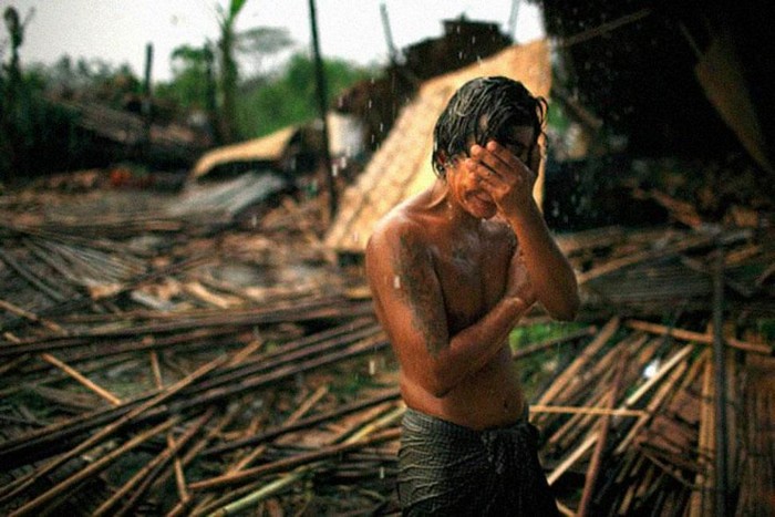  Hhaing The Yu, 29, holds his face in his hand as rain falls on the decimated remains of his home after a cyclone stroke Myanmar’s capital of Yangon. [2008] Source: Brian Sokol