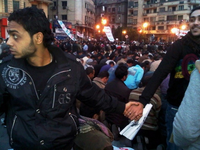  Christians protect Muslims in prayer at Tahrir Square during the Egyptian Revolution [2011] Source: Nevin Zaki