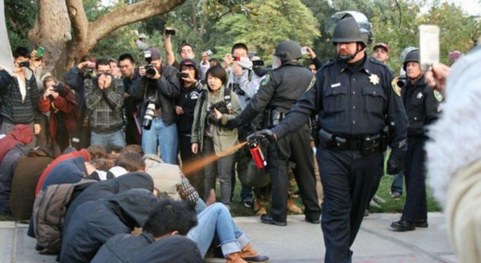  A police officer pepper-sprays Occupy protesters at the University of California [2011] Source: Unknown Photographer
