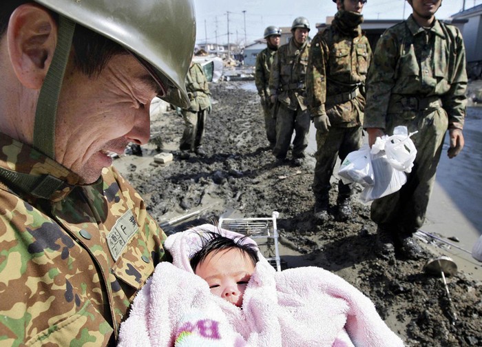  A 4-month-old baby girl is rescued from the rubble four days after the Japanese tsunami. [2011] Source: Reuters