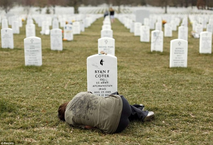  Lesleigh Coyer, 25, of Saginaw, Michigan, lies down in front of the grave of her brother, Ryan, who served with the U.S. Army in both Iraq and Afghanistan [2013] Source: Reuters