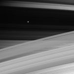 Overlapped rings, with moon Mimas in the distance